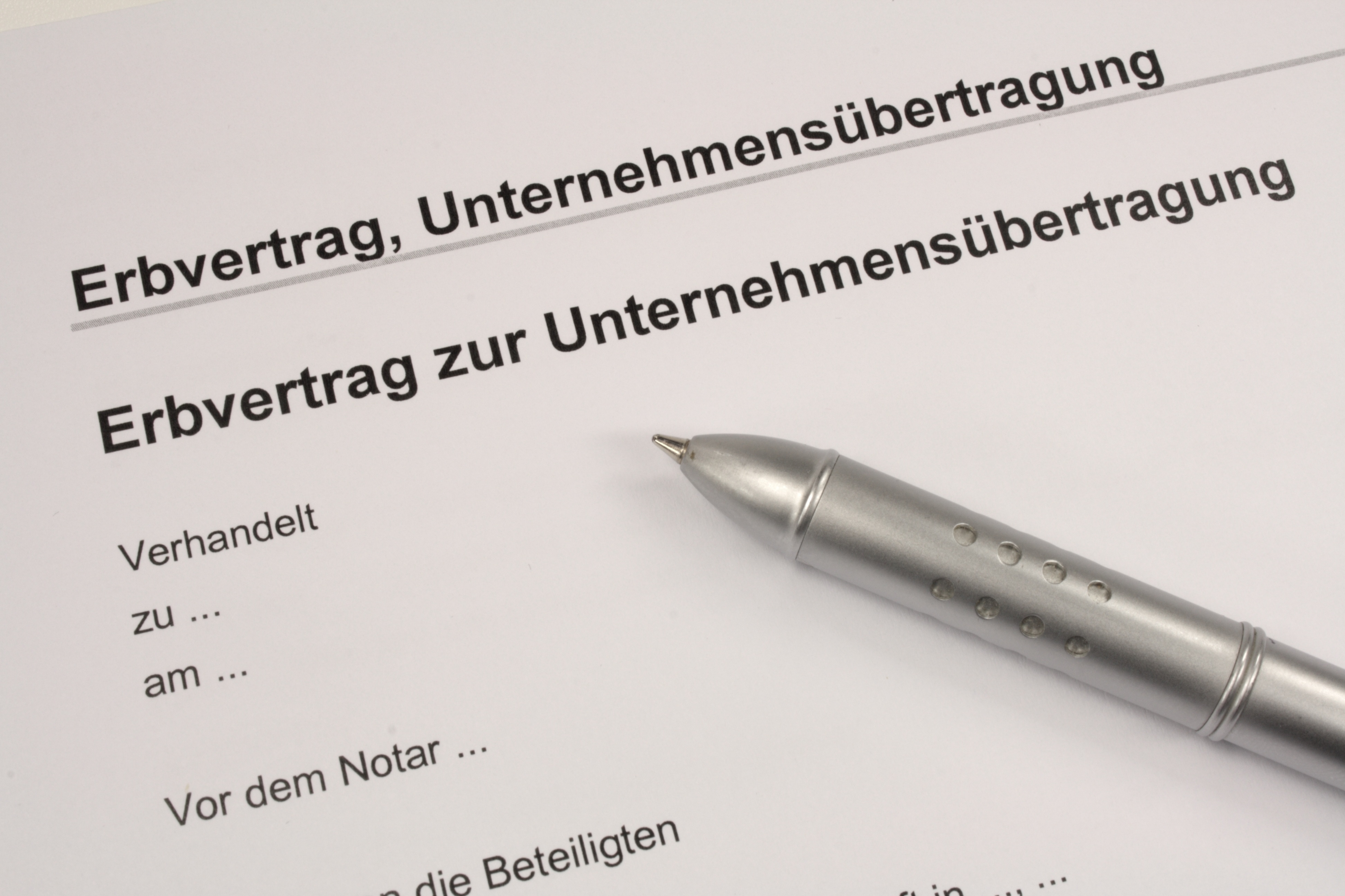 Erbvertrag Dokument zur Unternehmensübertragung mit Kugelschreiber