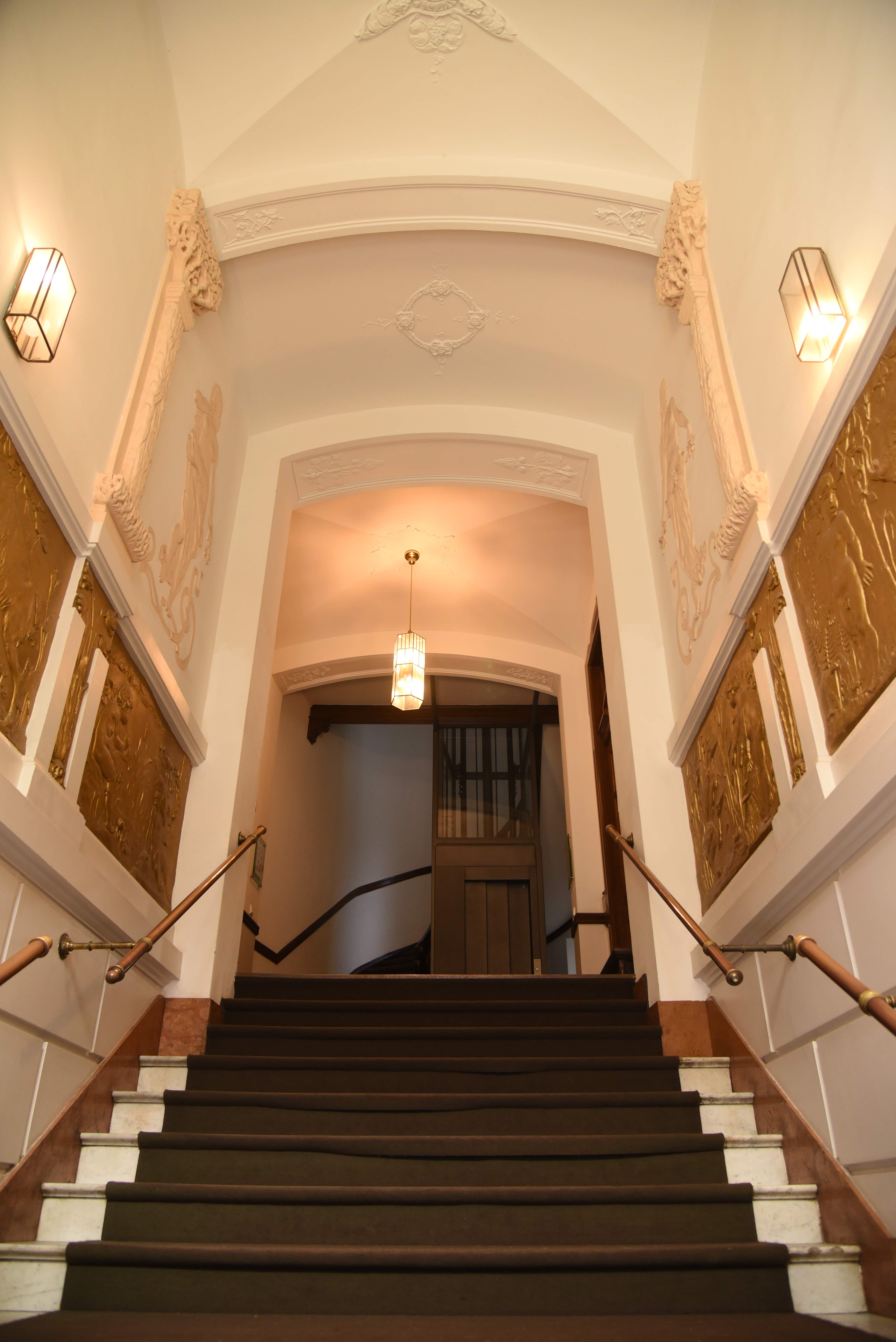 Elegantes Treppenhaus mit goldenen Wandpaneelen