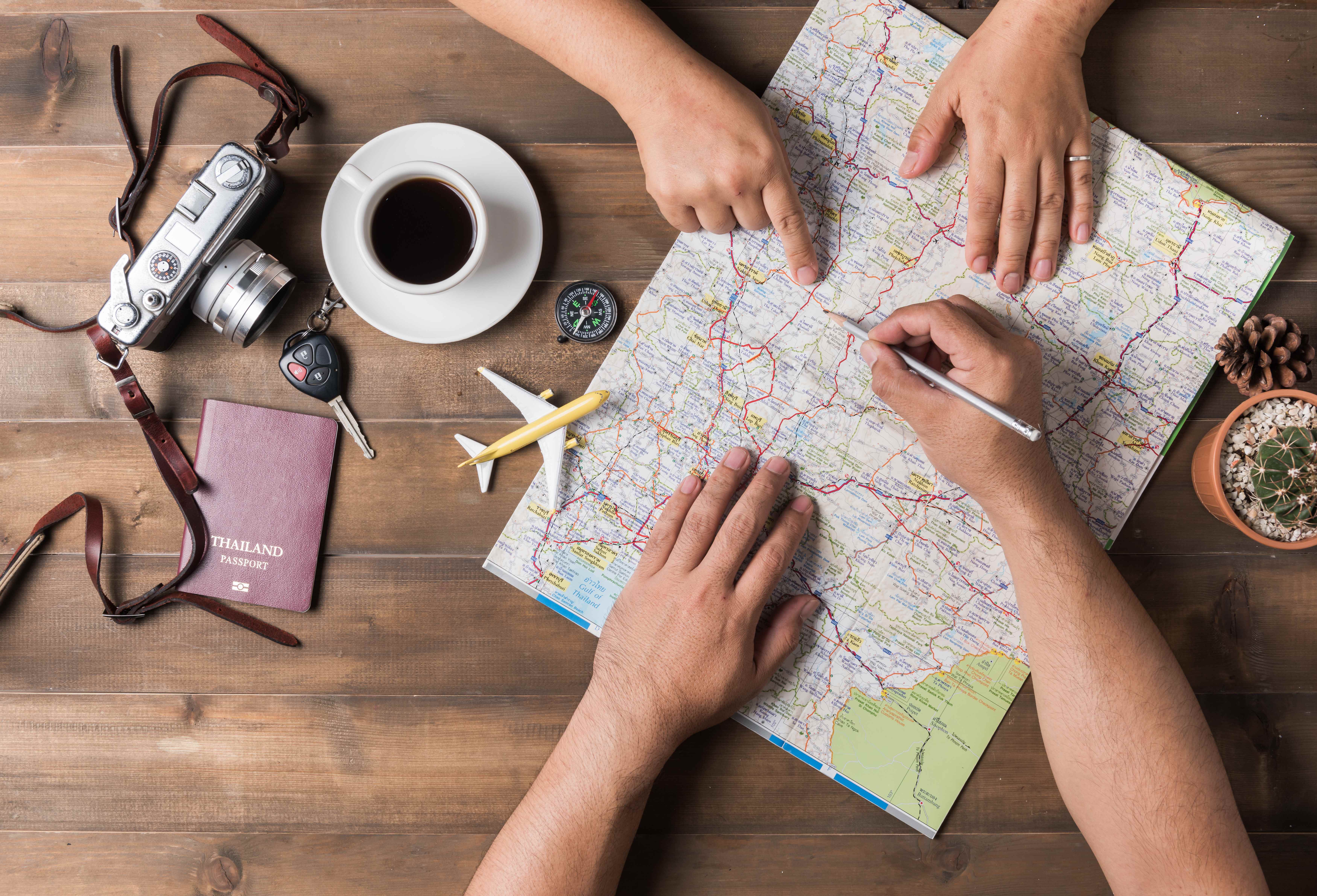 Urlaubsplanung mit Landkarte, Reisepass und Kamera